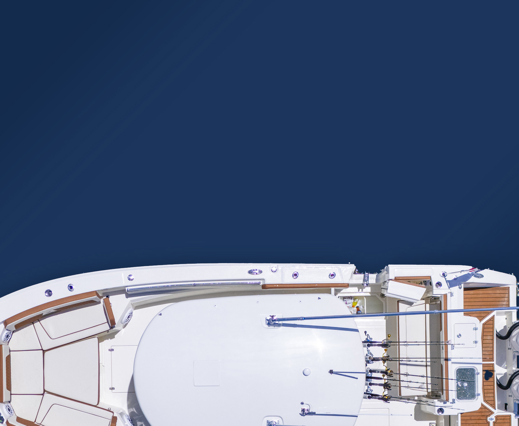 Overhead view of a sleek white boat on deep blue water. The boat's deck features fishing rods and twin outboard motors, conveying a sense of adventure.