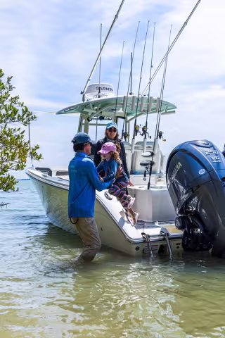 father helping daughter from boat